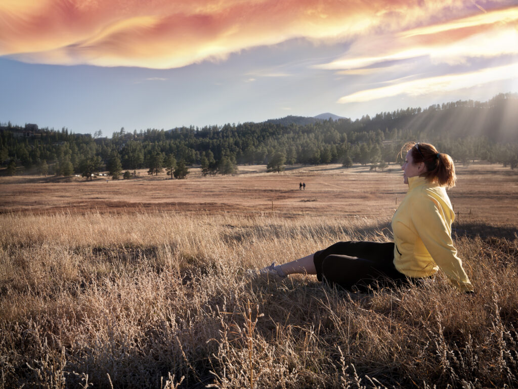 Woman Hiker Relaxing in Meadow at Sunset hiking in evergreen colorado